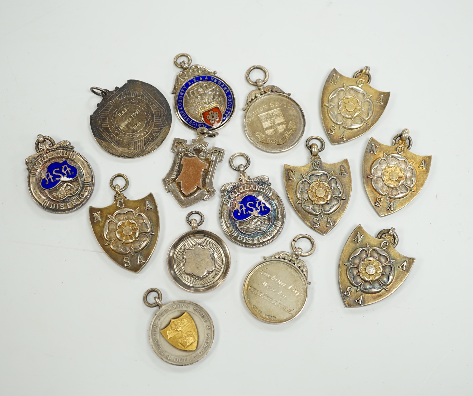 Twelve assorted mainly mid 20th century silver medals, including running and swimming (three with enamel) and two other white metal medals.